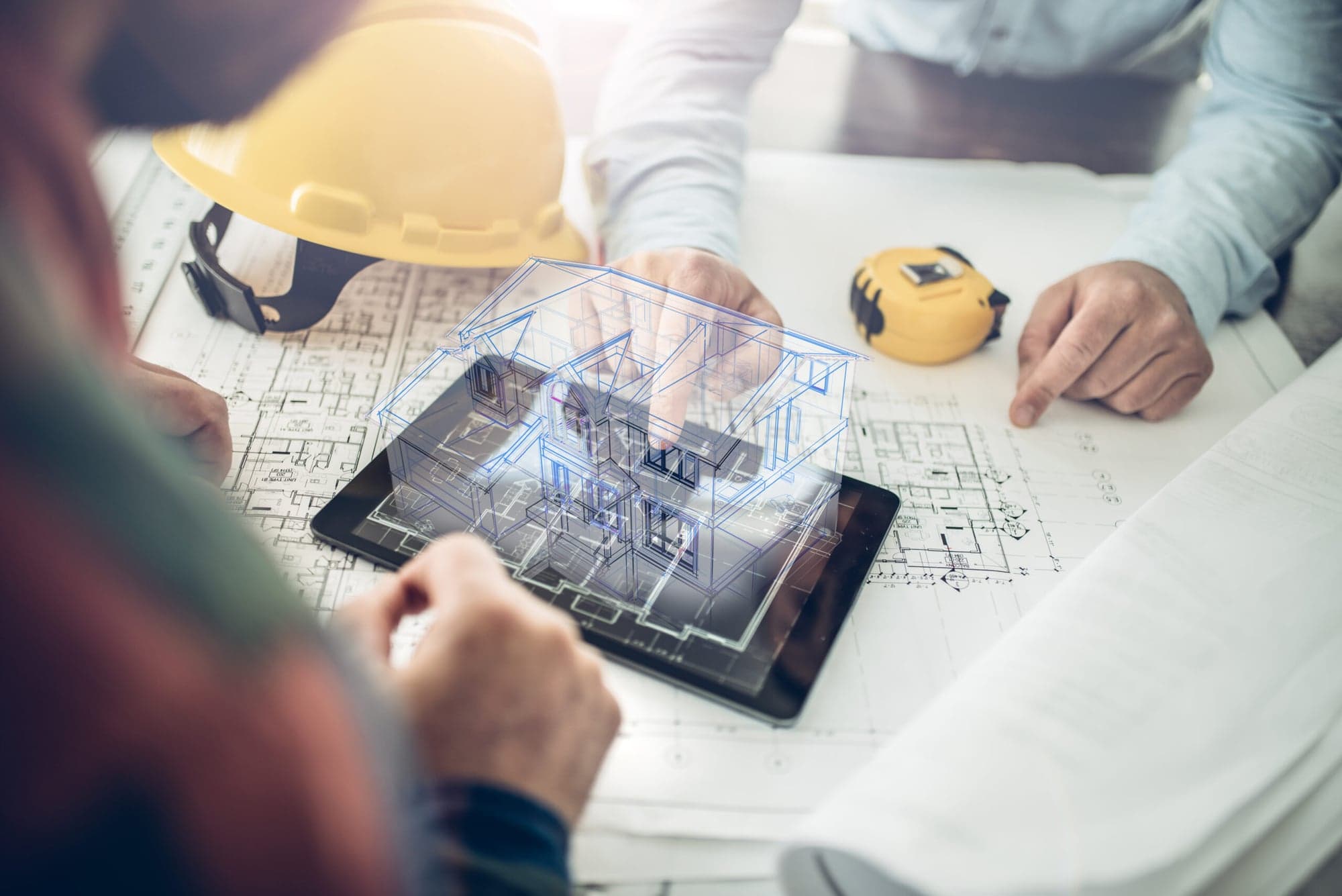 Architekt bei der digitalen Bestandsaufnahme mit 3D-Modell auf Tablet und Bauplänen – fbnSTUDIO Wiesbaden